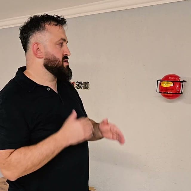 The founder of ORDEX next to a wall-mounted Super Fire Ball